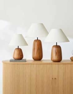 three wooden lamps sitting on top of a table