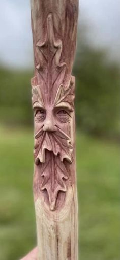 a carved wooden pole with a face on it