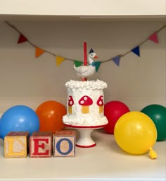 a birthday cake on a table surrounded by balloons