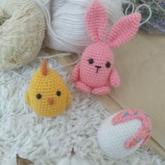 three crocheted stuffed animals sitting next to balls of yarn