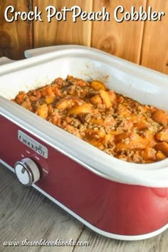 crock pot peach cobbler recipe in a red casserole dish on a wooden table