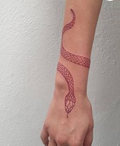 a woman's arm with a red snake tattoo on the left side of her wrist