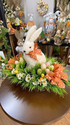 an arrangement of flowers and stuffed animals on a table in a room filled with other items