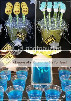 blue and yellow desserts are arranged in plastic cups with candy sticks on the top