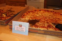 two boxes of pizza sitting on top of a table next to each other with one slice missing