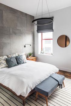 a bedroom with a large bed and two round mirrors on the wall above it's headboard