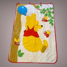 a winnie the pooh blanket hanging from a tree