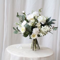 a bouquet of white flowers sitting on top of a table