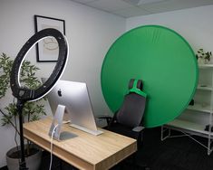 an apple computer sitting on top of a desk in front of a green circular screen