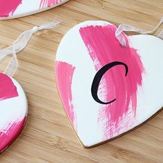 two painted heart shaped ornaments sitting on top of a wooden table