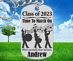 a keychain with the words class of 2013 time to march on it in front of a green field