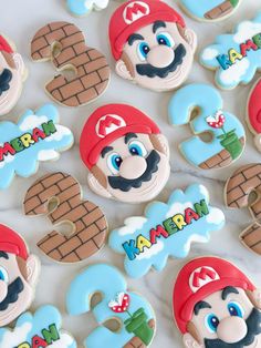 some decorated cookies with mario on them are sitting on a table next to each other