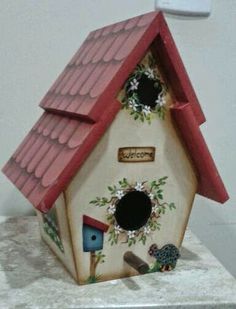 a ceramic birdhouse with a red roof