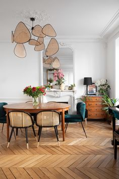 a dining room table with chairs around it and a chandelier hanging from the ceiling