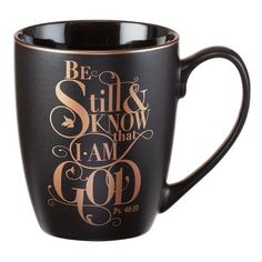 a black and gold coffee mug with the words be still and know that i am god