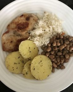 a white plate topped with meat, rice and beans