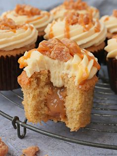 cupcakes with caramel filling and frosting on a wire rack, ready to be eaten