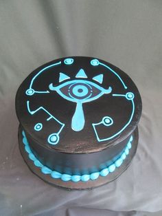 a black and blue cake with an evil eye on it