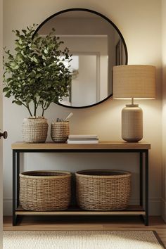 a table with two baskets and a mirror on it, next to a lamp that has a potted plant in front of it