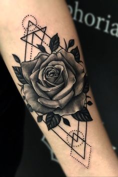 a black and white rose tattoo on the right arm with geometric shapes in the background