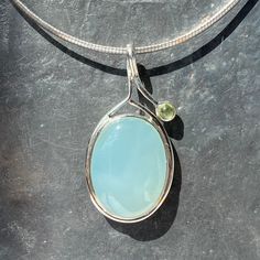 Blue Chalcedony pendant with peridot - peridot aqua chalcedony pendant   Natural stone  Metal - 925 sterling silver  Origin- India  Weight - 10 grams  Dimensions including loop - L 5 x B 2.5 x H 0.7 cm  L 2 x B 1 x H 0.3 inch  Post - Royalmail track and sign Chalcedony Cabochon Pendant Necklace, Chalcedony Necklace, Aqua Chalcedony, Blue Chalcedony, Smokey Quartz, Quartz Stone, Smoky Quartz, Sterling Silber, Pendant Necklaces