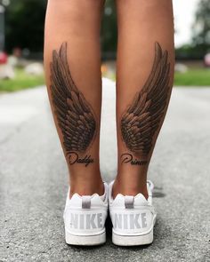 a woman's legs with tattoos and wings on her leg, both showing the word nike