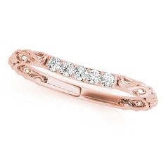 a rose gold ring with three diamonds on the side and an intricate design in the middle