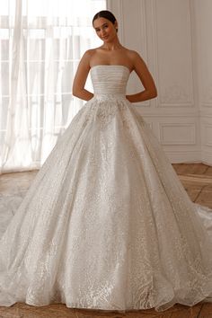 a woman in a wedding dress standing on the floor