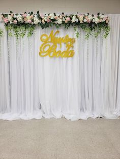 a white and gold wedding backdrop with flowers