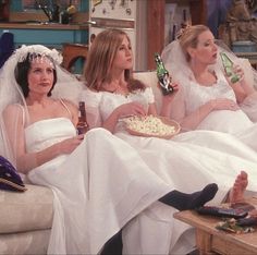 three brides sitting on a couch eating popcorn and drinking beer