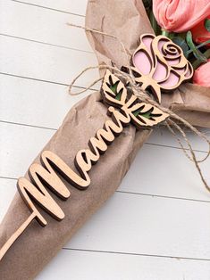 a bouquet of flowers is wrapped in brown paper with the word mama spelled on it