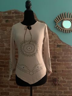 Vintage '90 long sleeve t-shirt made in Italy. Beautiful beige cotton blouse with ethnic sparkling printed mandalas. Cross ties closure. Pointed mandala decorated sleeves. Pointed font cut. Used in perfect condition Measurements: Fits M international Size on tag: M Colour: Brown / Beige Actual measurements when laid flat: Back: 33cm Chest: 46 cm Waist: 34 cm Length: 47-55 cm (pointed part) *All measurements such as chest, waist or hips are taken with the item flat and are doubled for circumferen Bohemian Long Sleeve Spring Shirt, Bohemian Long Sleeve Shirt For Spring, Bohemian Long Sleeve Fall Shirt, Spring Bohemian Long Sleeve Shirt, Long Sleeve Beige Cotton Top, Beige Long Sleeve Cotton Top, Beige Cotton Long Sleeve Top, Bohemian Tunic Tops For Fall, Bohemian Long Sleeve Tops For Summer