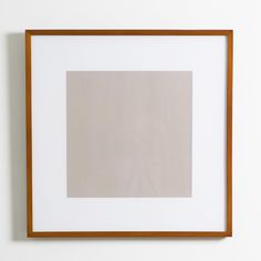 a white wall with a brown frame on it and a light colored square in the middle