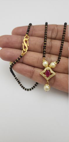 Mangalsutra is importance in Hindu culture and traditions. It is an ornament (more specifically a necklace) worn by women to signify marital status. .. Therefore, the groom tying the Mangalsutra around the bride's neck during the wedding rituals is considered a sacred Hindu custom. The white-red and white-green cz stones in this safa black beads necklace set are unique and beautiful. Superior quality stones make this sophisticated Indian jewelry a must-have. Each piece is handcrafted and made to Festive Black Beads Necklace For Gift, Festive Black Beads Necklace As Gift, Diwali Gift Black Beaded Necklace, Traditional Black Beaded Necklaces With Natural Stones, Diwali Gift Black Beads Necklace, Traditional Black Beads With Natural Stones, Black Beads Necklace For Wedding And Diwali, Traditional Handmade Black Beads, Festive Black Beads Necklace For Puja