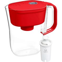 a red water pitcher next to a white cup