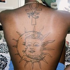 a person with a sun and cross tattoo on their back