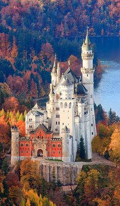 an aerial view of a castle in the middle of trees with fall foliage around it