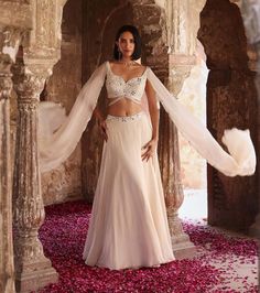 Indulge in sophistication with this embellished choli featuring attached flared sleeves, perfectly paired with a circular skirt adorned with an embellished belt and can-can detailing. This ensemble epitomizes elegance, offering a seamless blend of traditional charm and contemporary flair. Make a statement at any event or celebration with this exquisite outfit that exudes grace and style. Circular Skirt, Ivory Blouse, Embellished Belt, Can Can, Indian Clothes, Flared Sleeves, Indian Outfits, Western Fashion, Skirt