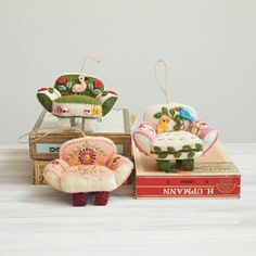 two miniature chairs and a small chair on top of a box with an ornament in the shape of a baby's prammode