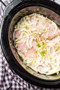 an overhead view of some food in a crock pot on a checkered table cloth