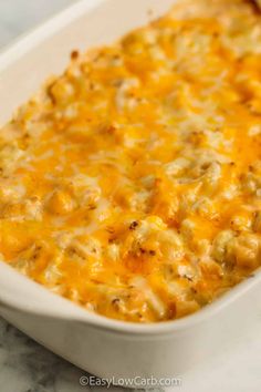 a casserole dish with cheese and chicken in it on a marble counter top