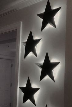 five black stars are hanging on the wall next to a white door and light fixture