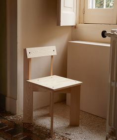 a small wooden chair sitting next to a window