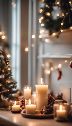 lit candles sit on a table in front of a christmas tree