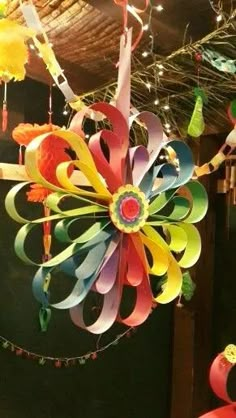 colorful wind chimes hanging from the ceiling in a room filled with lights and decorations