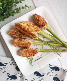 some food is sitting on a white plate with green onions and celery sticks