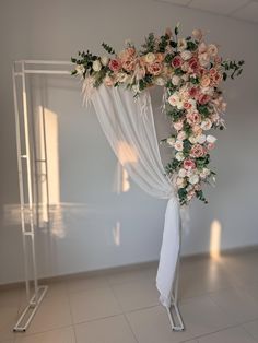 a white wedding arch decorated with flowers