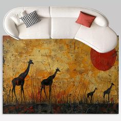 a living room with a white couch and painting on the wall above it that has two giraffes standing in tall grass