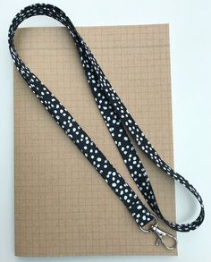 a black and white polka dot dog leash on a piece of brown paper next to a clipboard