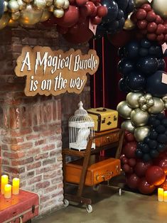 a bunch of balloons that are in front of a brick wall with a sign saying a magic bundle is on the way